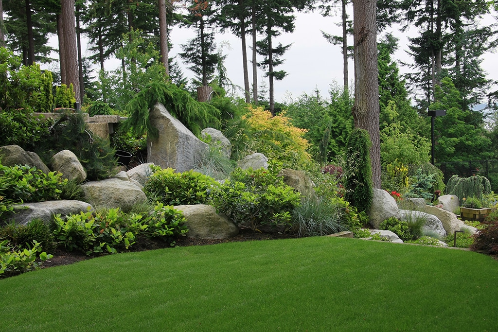Photo of a green landscape with decorative boulders.